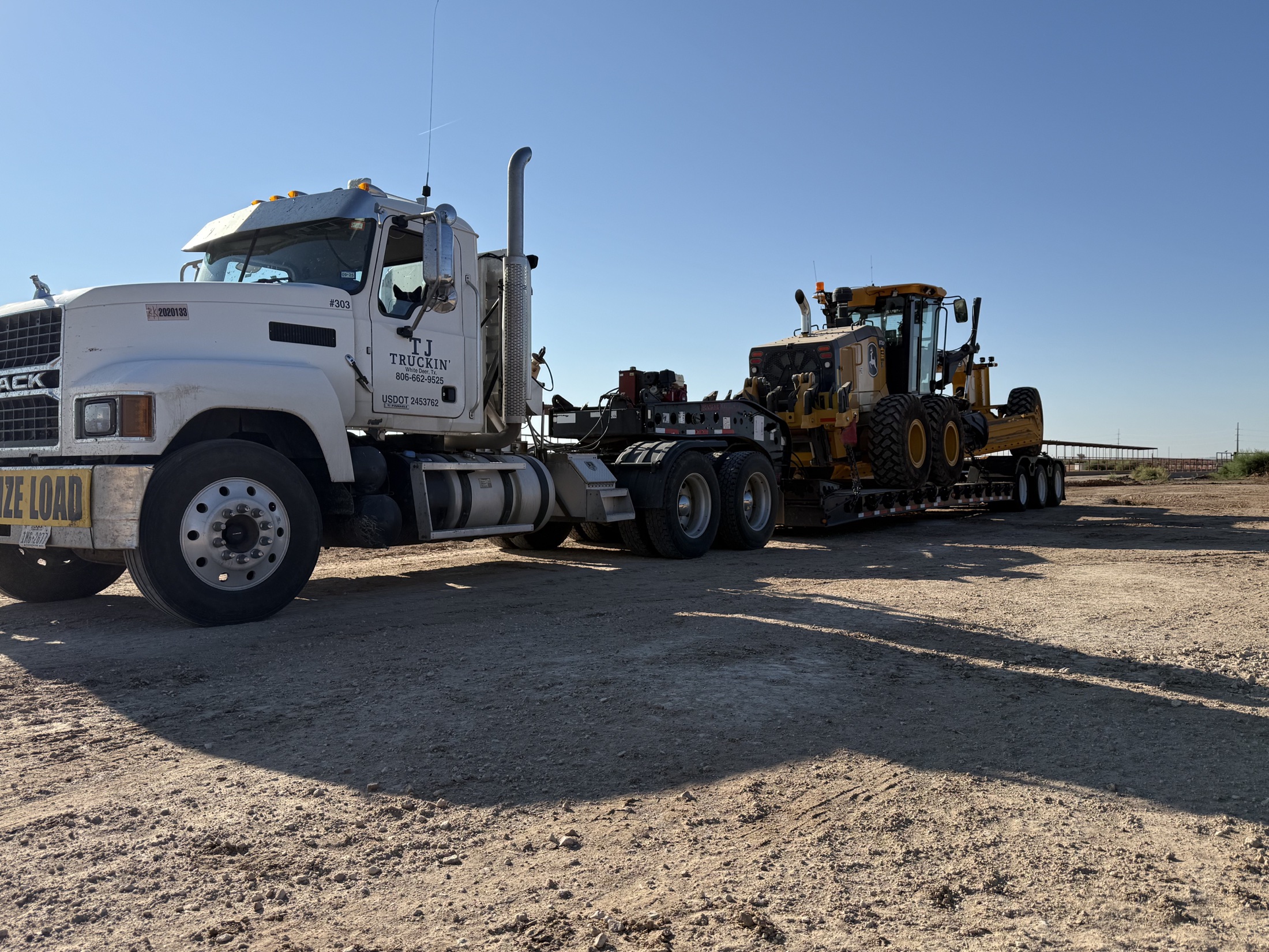 TJ Truckin’ heavy-haul truck transporting road-grading equipment